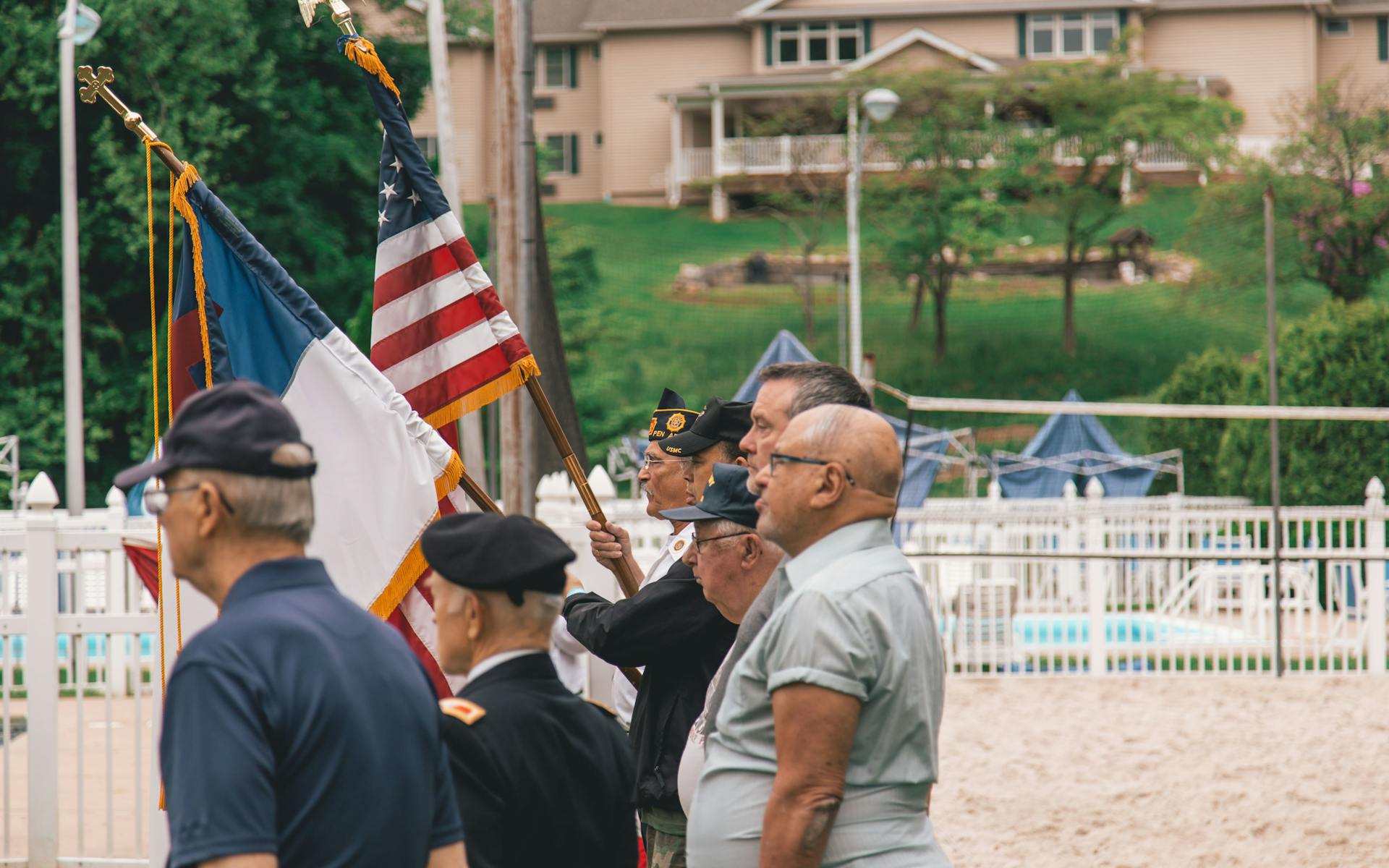 Veterans standing at ceremony with American flags